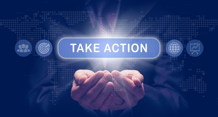 Businessmans cupped hands holding an Take Action business concept on a computerised display.