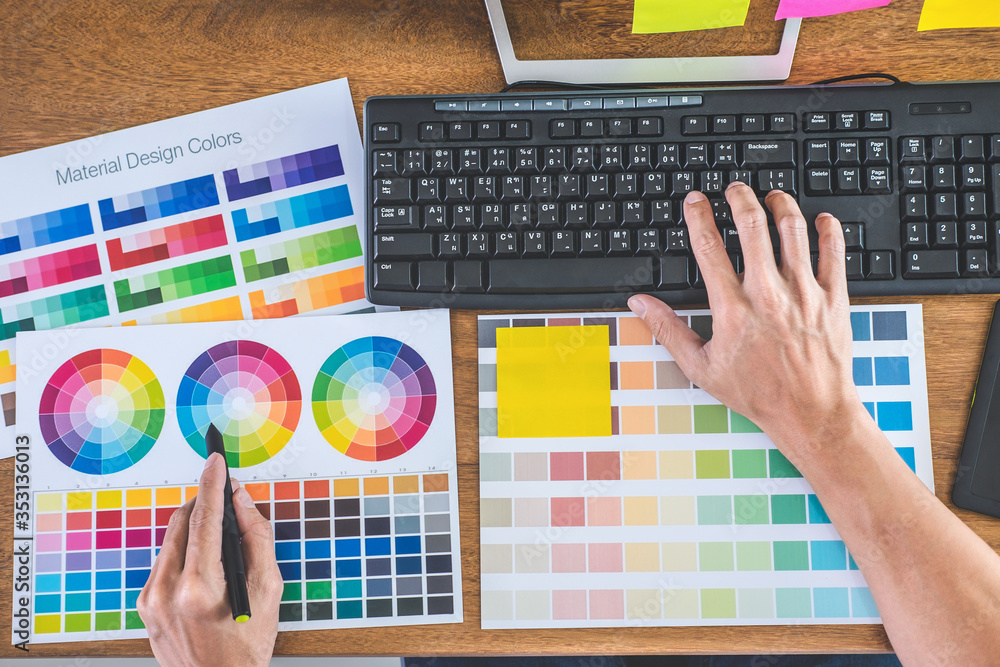 Aufkleber Image of male creative graphic designer working on color selection and drawing on graphics tablet at workplace with work tools and accessories in workspace