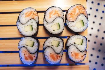 Sushi rolls with nori, salmon, rice, and avocado