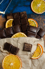 pieces of dark chocolate in a paper bag with dried oranges