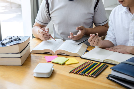 High school tutor or college student group sitting at desk in library studying and reading, doing homework and lesson practice preparing exam to entrance, education, teaching, learning concept