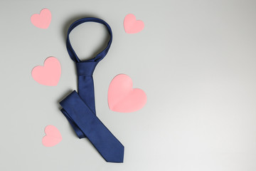  blue tie and pink hearts on a gray background. happy father's day holiday concept. top view, flat lay, copy space.