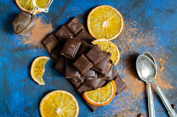 a slice of dark chocolate in cocoa powder with dried oranges