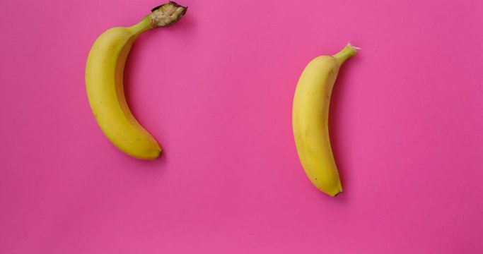 Bananas Are Dancing. Stop motion animation fruit. Food, healthy eating and vegetarian concept. Abstract colorful animation - banana pink background. 4K