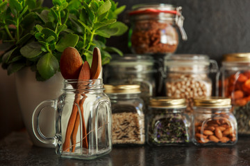 Food set. Raw cereals, pasta, groats, organic legumes and useful seeds in glass jars. Vegan source of protein and energy resources. Food storage in glass jars, eco shopping, on a dark background, Zero