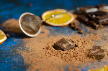 Obraz na płótnie Canvas slice of dark chocolate in cocoa powder