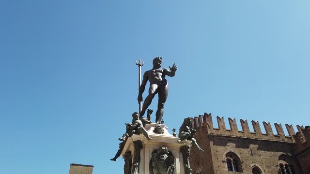 Neptune 1500s bronze statue fountain with gothic architecture background in Piazza Maggiore central square of Bologna town in Italy.