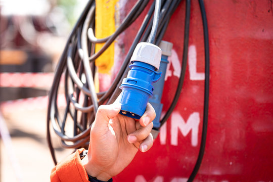 Close-uo at safety officer's hand during inspection or examine the Electricity power plug which is use in field operation. Heavy industry equipment object photo.