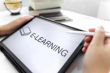 Young woman watching on digital tablet for e-learning.