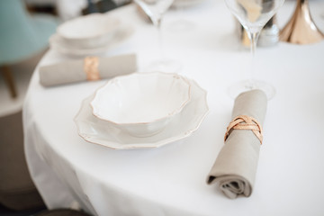 Served tables in white colors for banquet. Served table with wineglasseServed tables in white colors for banquet. Served table with wineglasses and plates close-ups and plates