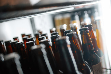 Bottles of beer in the fridge of a bar. Different focus
