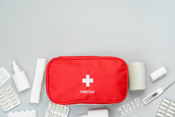 First aid kit red bag with medical equipment and medications for emergency treatment. Top view flat...