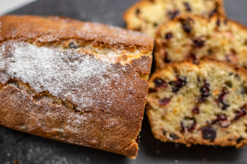 Orange pound cake with cranberries on a black stone plate