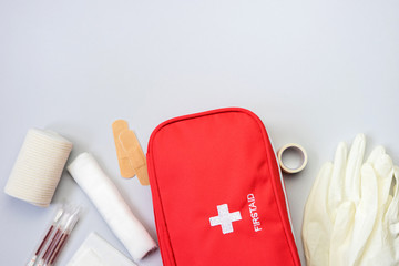 First aid kit red bag with medical equipment and medications for emergency treatment. Top view flat...