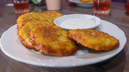 Potato pancakes, draniki, hash browns or fritters served with fresh cream.