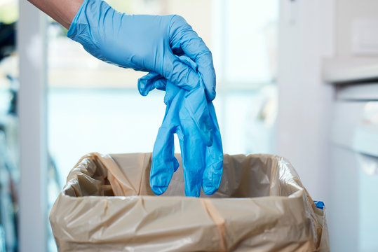 man throwing latex gloves to the trash can