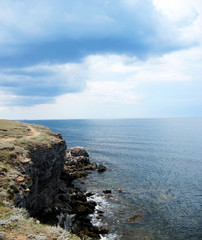 Steep rocky shore.  A small trail near the shore.                 