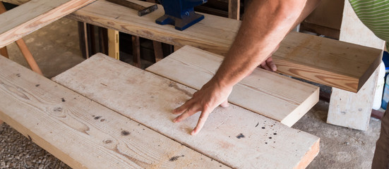 Male carpenter working on old wood in a retro vintage workshop.