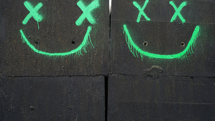 Cheerful cute drawing of green graffiti on black concrete slabs