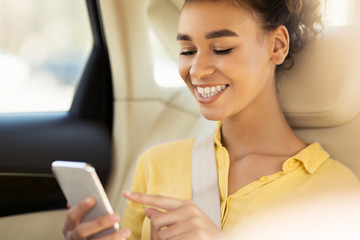 African American Girl Using Smartphone Sitting In Car During Ride