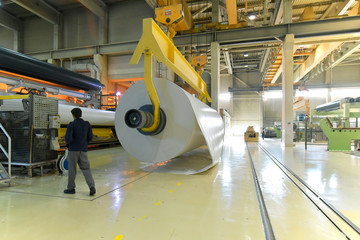 produktion von papier in einer Fabrik - Papierrolle am Kran // paper mill: production of paper...