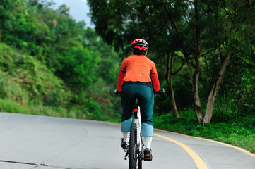 Fototapeta premium Woman cycling on bike path at park on sunny day