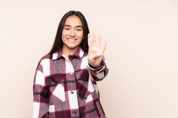 Young Indian woman isolated on beige background happy and counting four with fingers