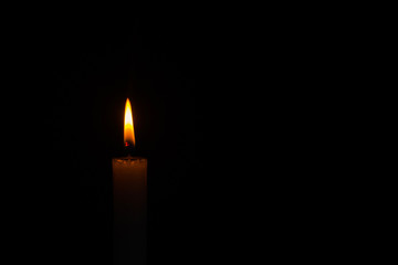 part of a lit candle in the dark