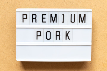 Lightbox with word premium pork on wood background
