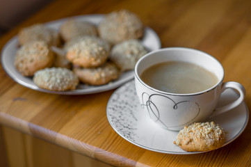 Cup of black coffee and plate with peanut butter cookies on a table.