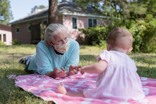 Grandmother Social Distancing With Grandchildren Wearing A Facemask  