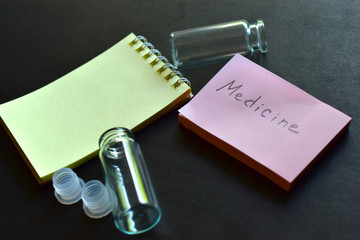 Two colored notebooks and medicine containers on a black background