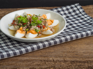 Close up boiled egg salad on wood background. Thai food concept.