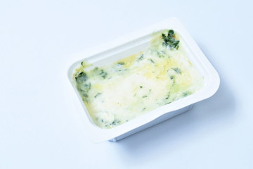 baked spinach with cheese in plastic cup on white background
