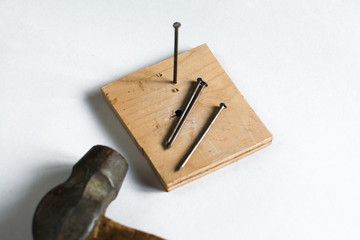 metal nail and hammer hammered into a wooden Board on a white background isolate