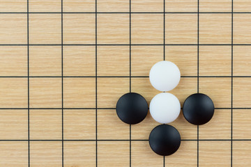 Simple training position of black and white stones on the playing field (gohan) of Chinese game go © Evgeniya