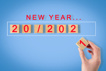 hand folds 2021 cubes on a blue background