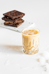 Tasty iced coffee latte with milk and ice cubes, cold drink in crystal glass on white background.