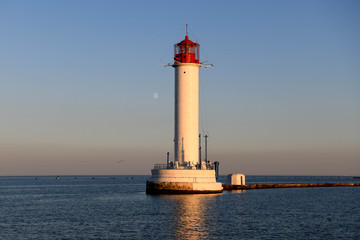 The Odessa Lighthouse at sunset with the moon in the background.