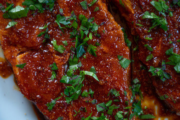 fresh neck steak of pork marinated with paprika and oil with fresh herbs on top ready to grill
