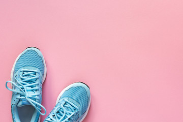 Blue sneakers isolated on a pink background, seasonal shoes for walking and sports, copy space, top view