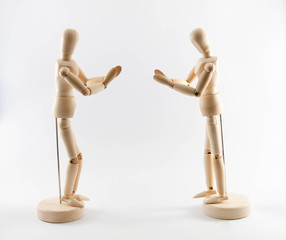 Two wooden puppets paying respect and greeting by pressing hand together on chest. Thai style...