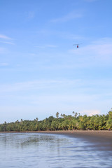 Obraz na płótnie Canvas Helicopter flying over an empty tropical beach