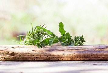 Fresh fragrant herbs on old wooden board