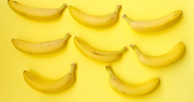 Bananas Are Dancing. Stop motion animation fruit. Food, healthy eating and vegetarian concept. Stop motion of bananas on yellow background. 4K