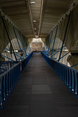 
blue footbridge under the cement bridge on which is a road for cars in the city of Prague in the spring