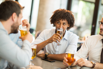 conversation of young businessmen while sitting in a cafe and drinking cold wheat beer