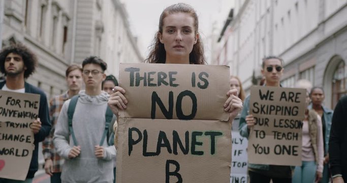 Activists silently protesting against global warming.  Group of protestors standing on the street with posters. Nonviolent demonstration. 
