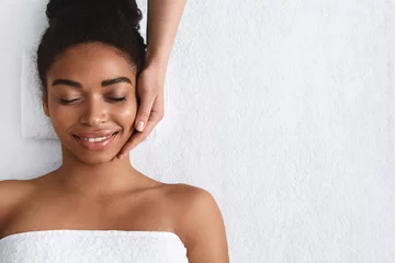 Poster Joyful african girl having face massage at spa © Prostock-studio