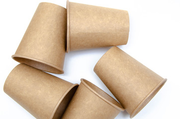 Brown paper cup for coffee, tea, a drink from environmental materials on a white background. A bunch of glasses. Glasses lie on their side in a circle in the form of a ring. Front and top view. Macro